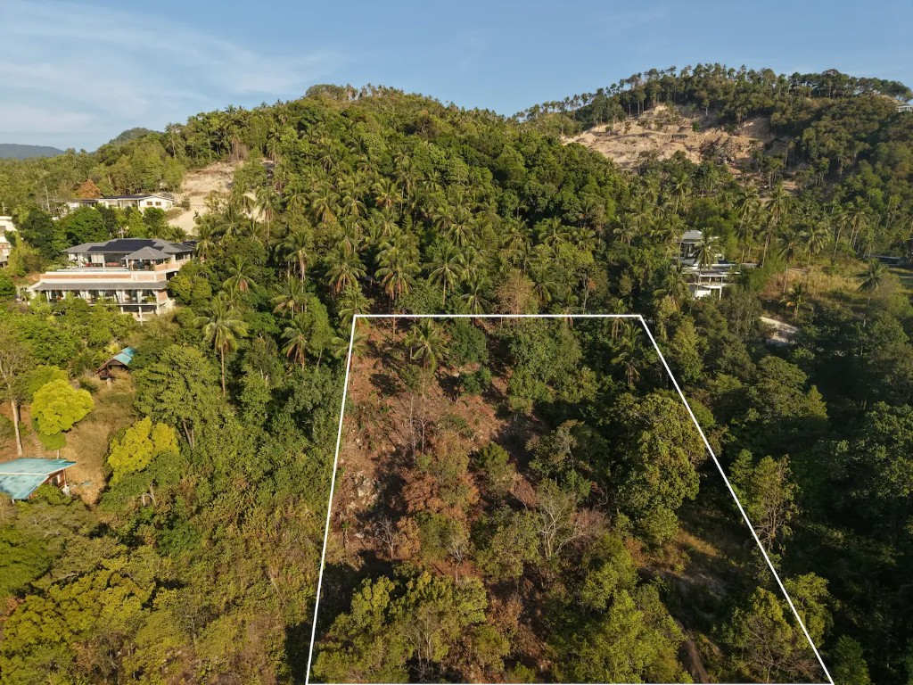 Aerial view of the plot on hillside with adjacent luxury villas