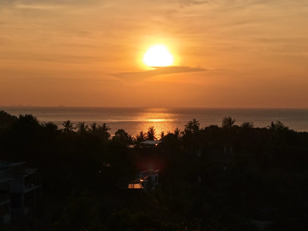 Dramatic orange sunset over Haad Salad bay from drone